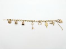 A 9ct gold charm bracelet with seven 9ct gold charms and a 9ct gold padlock, 14.9g