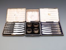 Four cased napkin rings and two cased sets of silver handled knives.
