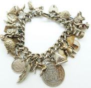 A large silver charm bracelet including a donkey charm, cars, boats, coins etc