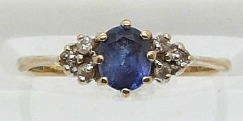 A 9ct gold ring set with an oval sapphire and six diamonds (size J)