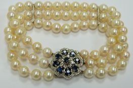 A three strand cultured pearl bracelet with 9ct white gold clasp set with nine round cut