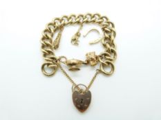 A 9ct gold curb link bracelet with five charms including a horseshoe, lamp and monkey, 74g