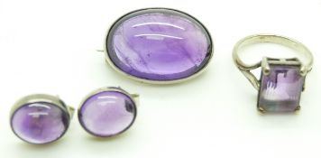 A silver brooch set with an amethyst cabochon, matching earrings and a silver ring set with amethyst