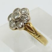 An 18ct gold ring set with seven round cut diamonds in a cluster (size G/H)