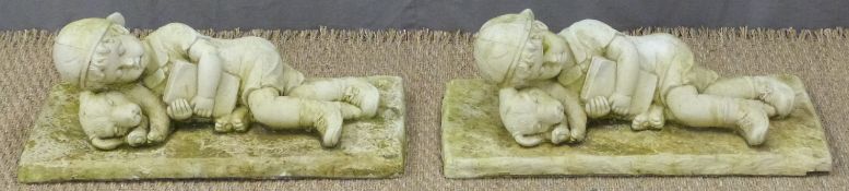 A pair of garden figures of a boy sleeping, length 57cm