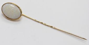 A stick pin set with an oval opal cabochon