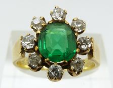 Victorian ring set with a faux emerald surrounded by diamonds, dated 1883