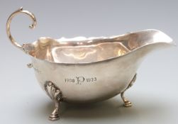 George V hallmarked silver sauce boat with shaped edge, raised on three feet, Birmingham 1930