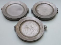 Three pewter plate warmers, each with London touch marks and marked E.W, width 28.5cm