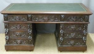 Carved oak twin pedestal desk, fitted four drawers to each side and single drawer above knee hole,