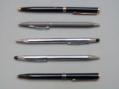 Five Colibri and Cross ballpoint pens.