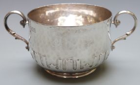 George V hallmarked silver two handled bowl with Arts and Crafts hammered and card cut decoration,