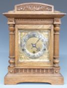 Oak cased c1900 shelf/bracket clock, the brass Arabic dial with silvered chapter ring, armorial