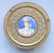 A 19th century gilt metal circular trinket box with portrait miniature of a lady with tiara and