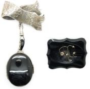 A silver brooch with foliate decoration, a Victorian locket set with black enamel and seed pearls