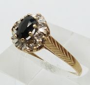 A 9ct gold ring set with an oval sapphire surrounded by diamonds (size R)