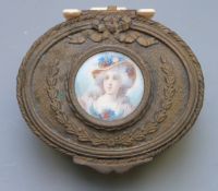 A 19th or early 20th century gilt metal oval trinket box with foliate and bow decoration, the top