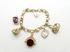 A 9ct gold charm bracelet with two 9ct gold fobs, two 9ct gold swivel fob charms and a ring charm,