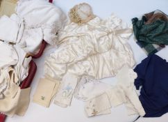 A vintage suitcase containing a quantity of linen, a wedding dress and garland