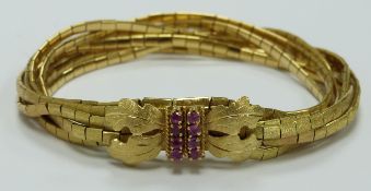 An 18ct gold bracelet made up of flat textured links set with rubies to the clasp, 49.5g