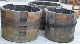 Three coopered barrel style garden planters, height of tallest 35cm