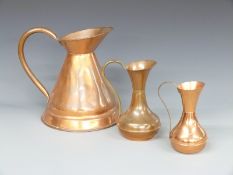 A trio of copper jugs, largest 30cm tall