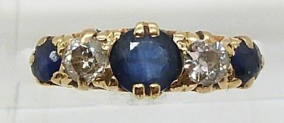 An 18ct gold ring set with three round cut sapphires, the centre stone approximately 0.6ct, and