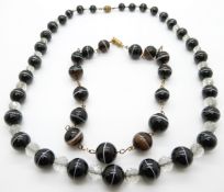 A banded agate necklace made up of alternating glass and agate beads and another banded agate