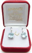 A pair of 18ct white gold earrings each set with a mixed cushion cut aquamarine measuring