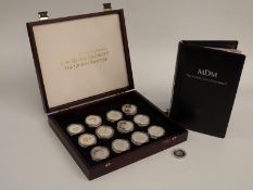 A cased set of thirteen Queen Mother Royal Commemorative crowns with booklet of certificates
