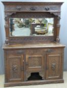 Carved oak mirror backed dresser, the back having bevelled glass mirror, the base fitted drawers,