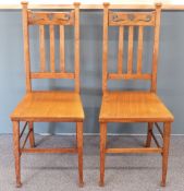 A pair of Arts & Crafts oak chairs with plank seats in the Liberty / Heals style