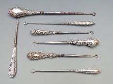 Seven various early 20th century hallmarked silver button hooks, length of longest 24cm
