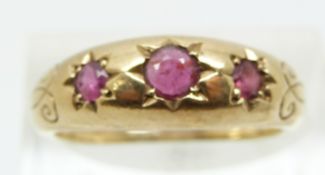 A 9ct gold ring set with three rubies in star settings (size P)