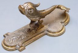 Late 19th/ early 20thC figural brass dolphin desk paperclip, length 13.5cm.