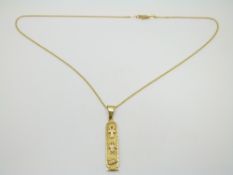 A yellow metal Egyptian pendant on a 9ct gold chain, 4.1g