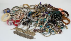 A collection of costume jewellery including beaded necklaces, silver bangles, silver curb link