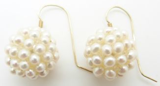 A pair of earrings set with pearls in clusters with 14k gold fittings