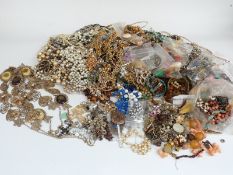 A collection of costume jewellery including vintage brooches, earrings, beads, bangles etc