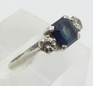 A platinum ring set with a square cut sapphire and two diamonds (size L)