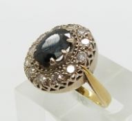An 18ct gold ring set with an oval sapphire surrounded by round cut diamonds each approximately 0.