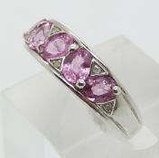 A 9ct white gold ring set with five oval cut pink sapphires and diamonds (size P)