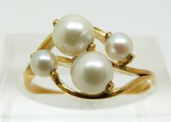 A yellow metal ring set with four pearls (size M)