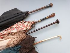 A collection of Edwardian lace parasols including lace, white metalmounted and gold stud inlaid