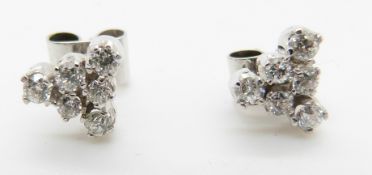 A pair of white gold earrings set with six round cut diamonds to each, total diamond weight
