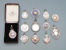 Twelve hallmarked silver and white metal mainly sports medals including darts, football, animal