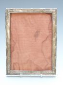 George V hallmarked silver photograph frame with embossed decoration, to suit approx 8 x 6 inch