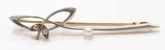 A 15ct gold brooch set with a pearl and two diamonds with a platinum finish, 5cm