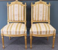A pair of late 19thC Louis XVI style upholstered giltwood salon chairs