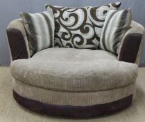 A contemporary circular armchair on swivel base, with high tapered arms and patterned cushions,